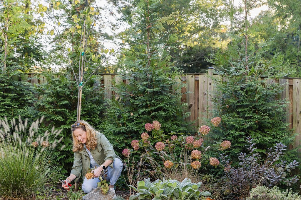 woman kneeling down in yard to create outdoor space