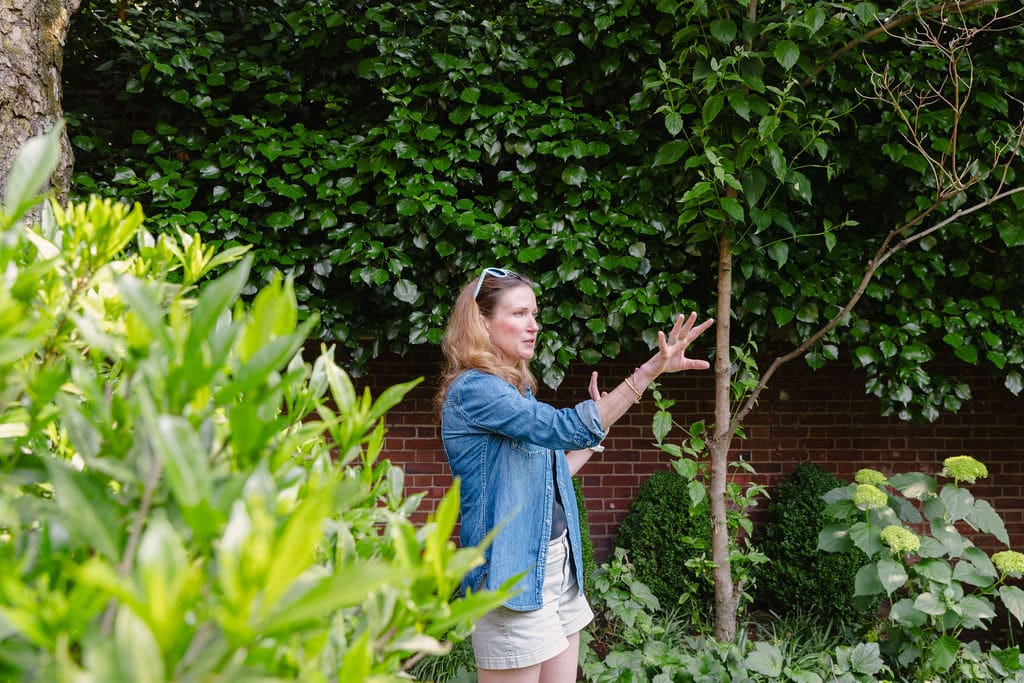 Jenna of lanier landscapes walking through client's backyard during landscaping consultaiton
